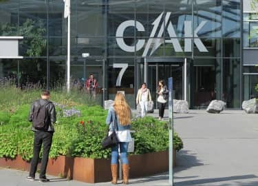 De foto toont mensen bij het gebouw van het CAK