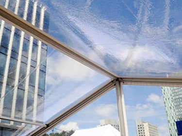 De foto toont een afbeelding van een transparante tent midden in een kantorenpark