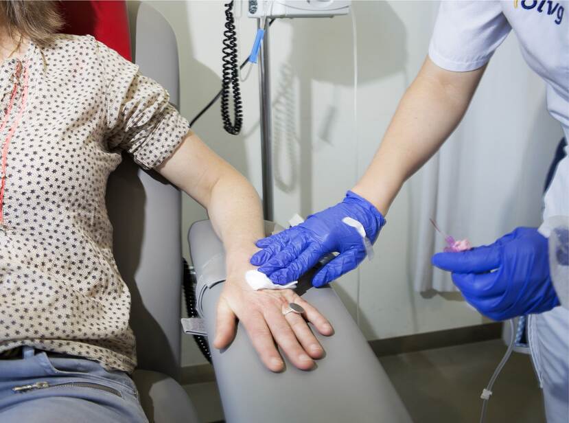 De foto toont een patiënt met borstkanker die via een infuus een medicijn krijgt toegediend.