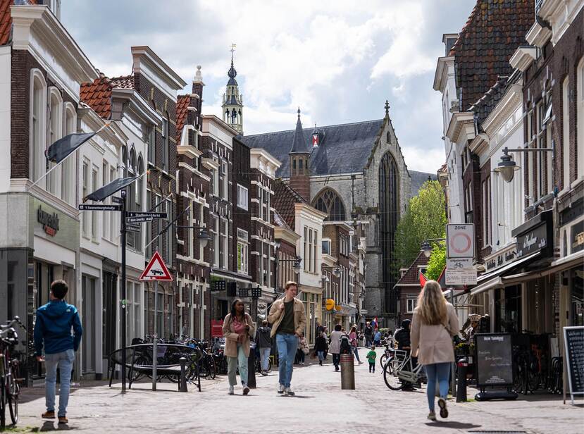Op de foto loopt een aantal mensen over straat in het centrum van een Nederlandse stad.